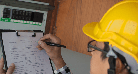 PEC employee conducting an energy audit by taking down measurements from a fuse box